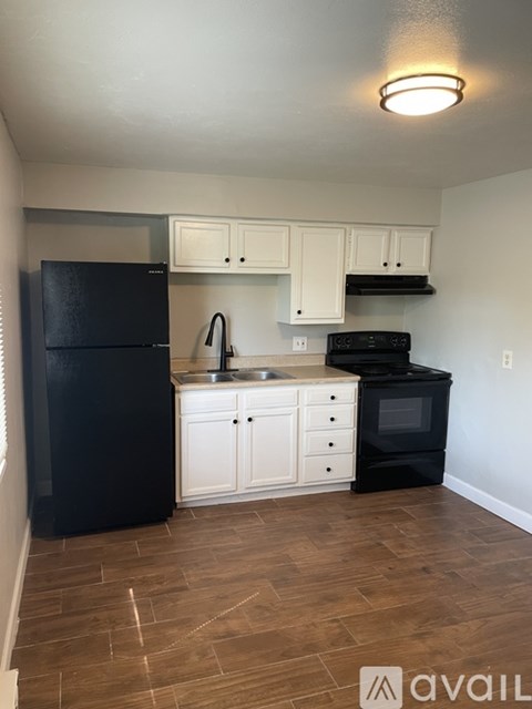 A kitchen with black appliances and white cabinets.