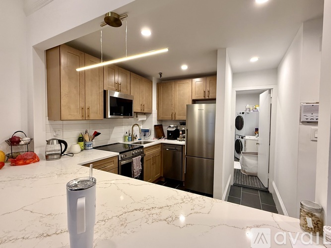 A kitchen with wooden cabinets and a stainless steel refrigerator.