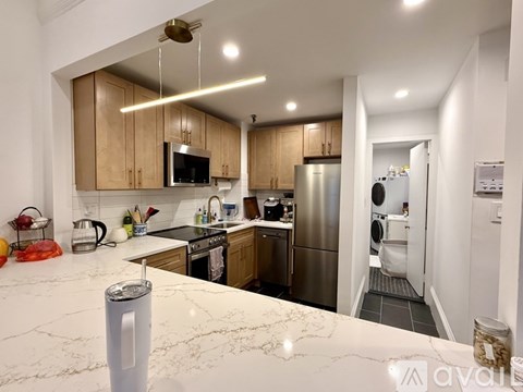 A kitchen with wooden cabinets and a stainless steel refrigerator.