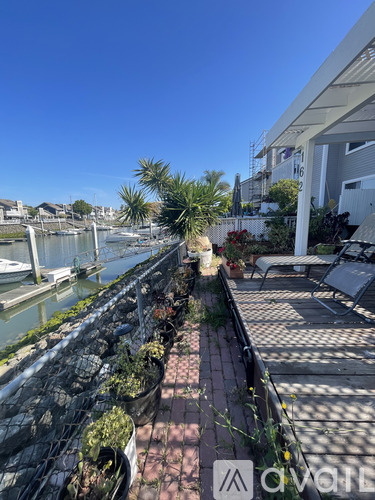 A patio with a table and chairs overlooks a body of water.