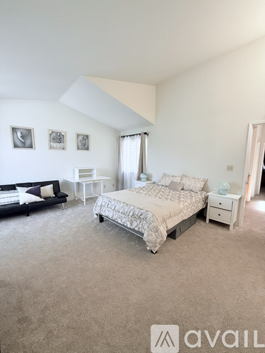A bedroom with a large bed and a couch.