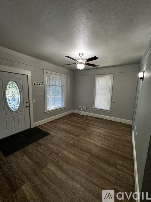 A room with a ceiling fan and a window with blinds.