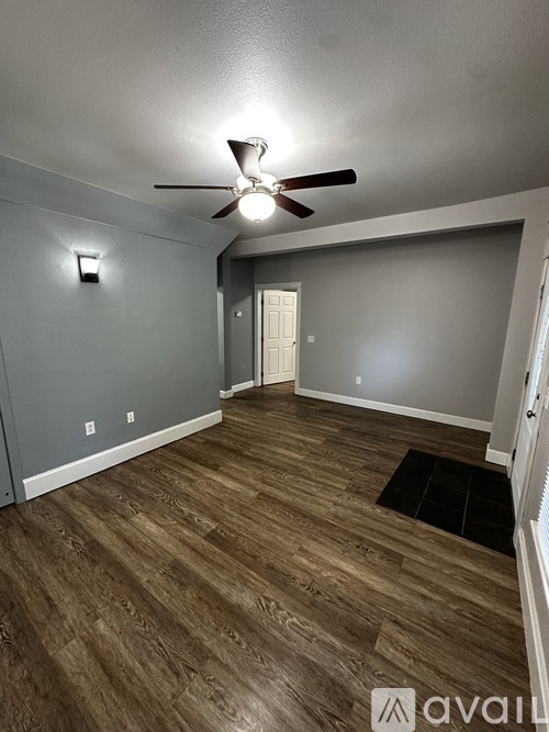 A room with a white door and a wooden floor.