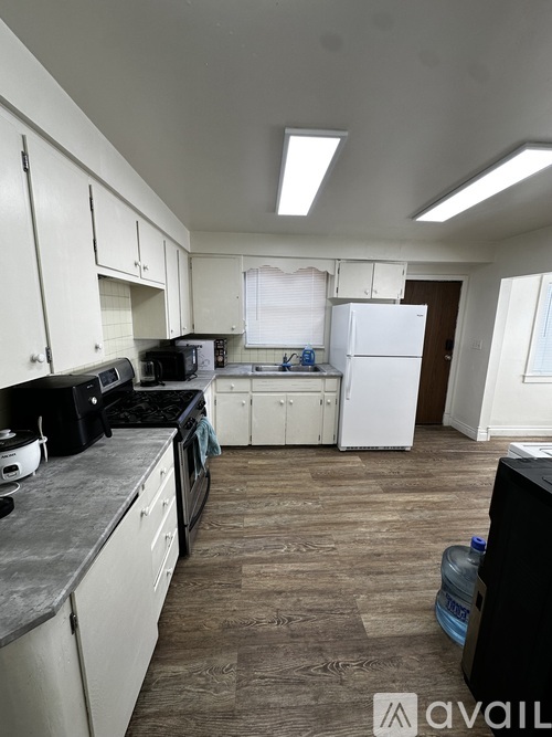 A kitchen with white cabinets and a black stove top.
