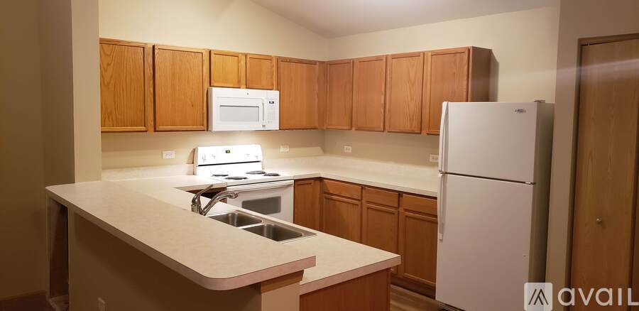 A kitchen with wooden cabinets and a white fridge.