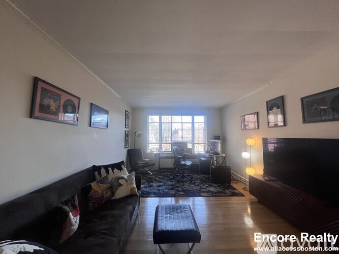 A living room with a black couch and a coffee table.