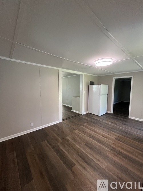 A room with wooden flooring and a white ceiling with a light fixture.