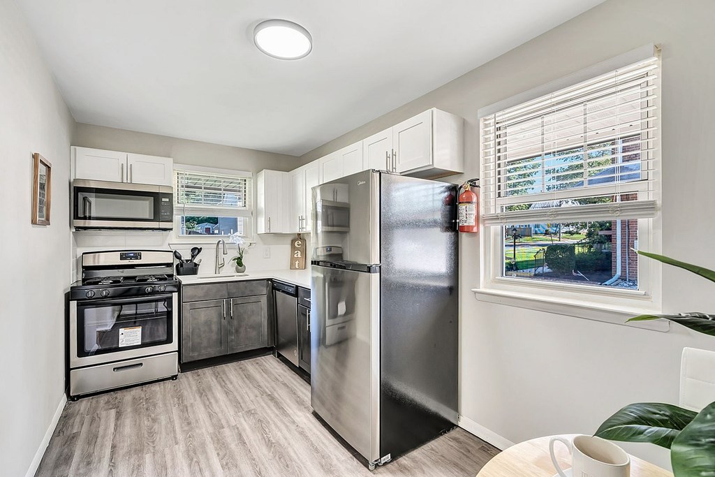 A kitchen with a refrigerator, oven, and microwave.