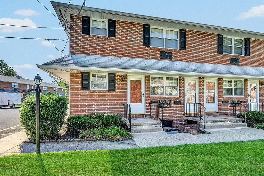 A red brick house with a white door and windows.