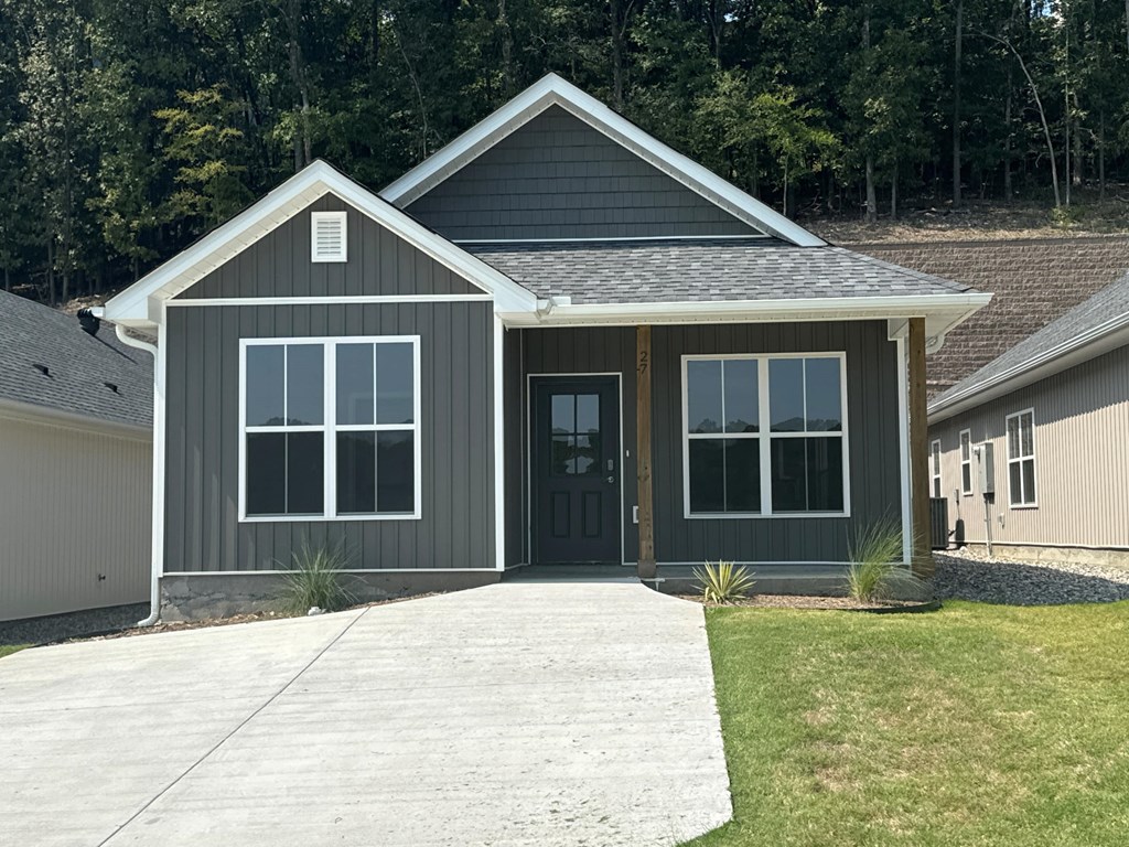 A grey house with a black door and windows.