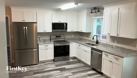 A kitchen with white cabinets and a granite countertop.