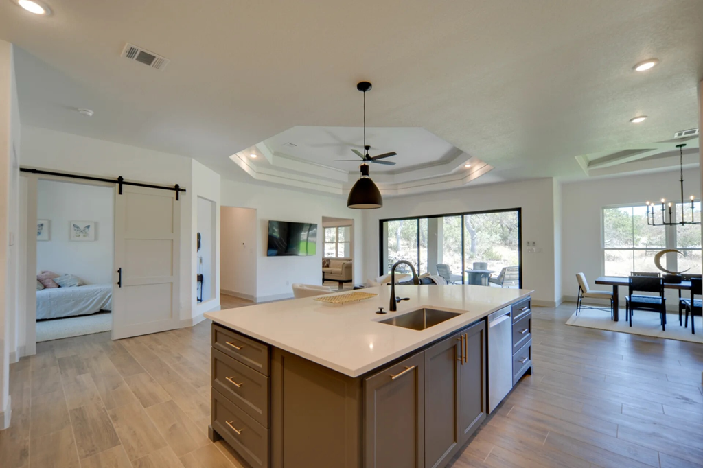 A modern kitchen with a large island and a dining area.