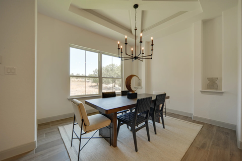 A dining room with a wooden table and chairs.