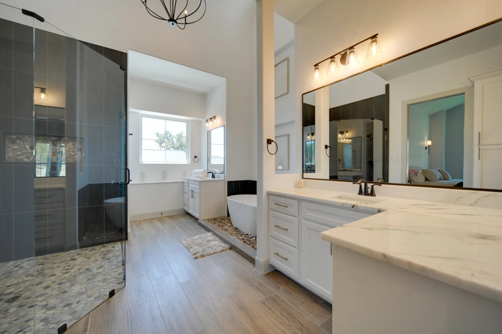 A bathroom with a marble countertop and a walk-in shower.