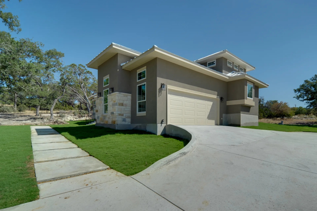 A modern house with a grey exterior and a white garage door.