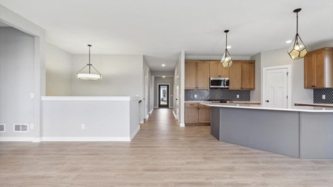 A spacious kitchen with wooden cabinets and a white island.