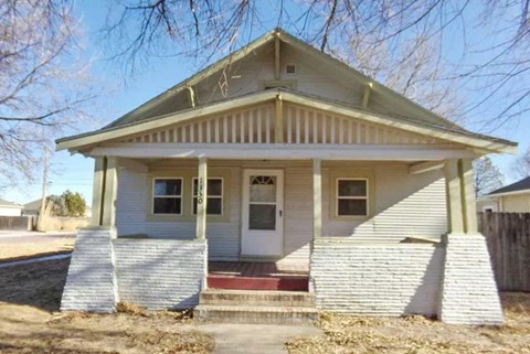 A small house with a porch and a front door.