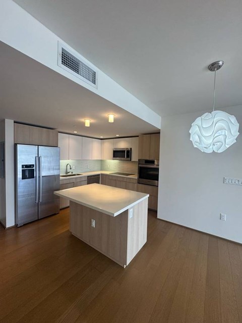A modern kitchen with a wooden island in the middle.