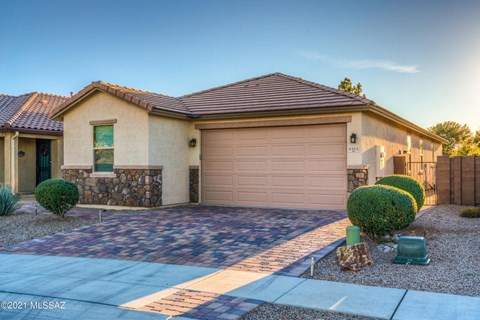 A house with a brown roof and a tan garage door.