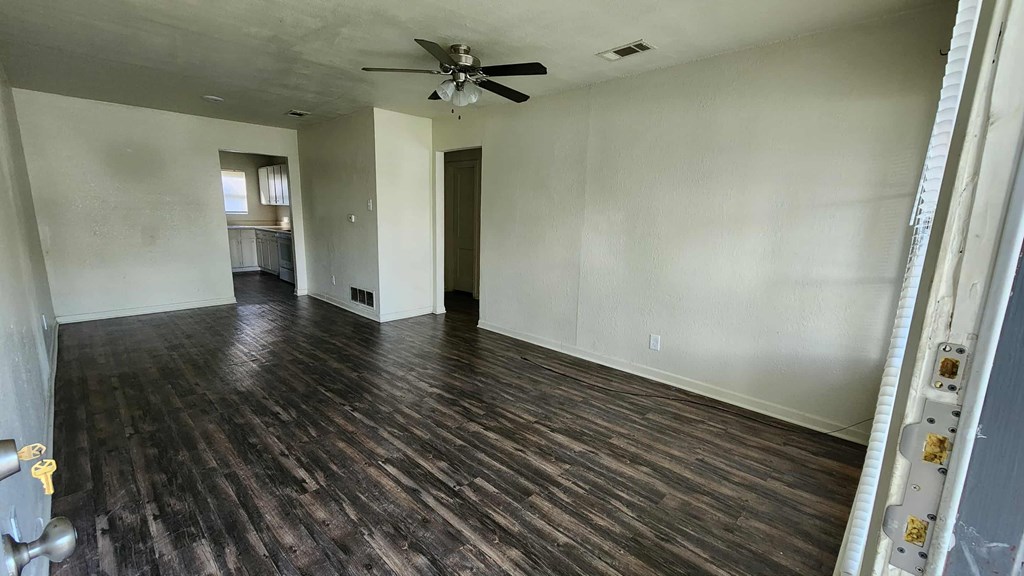 A room with wooden floors and a ceiling fan.