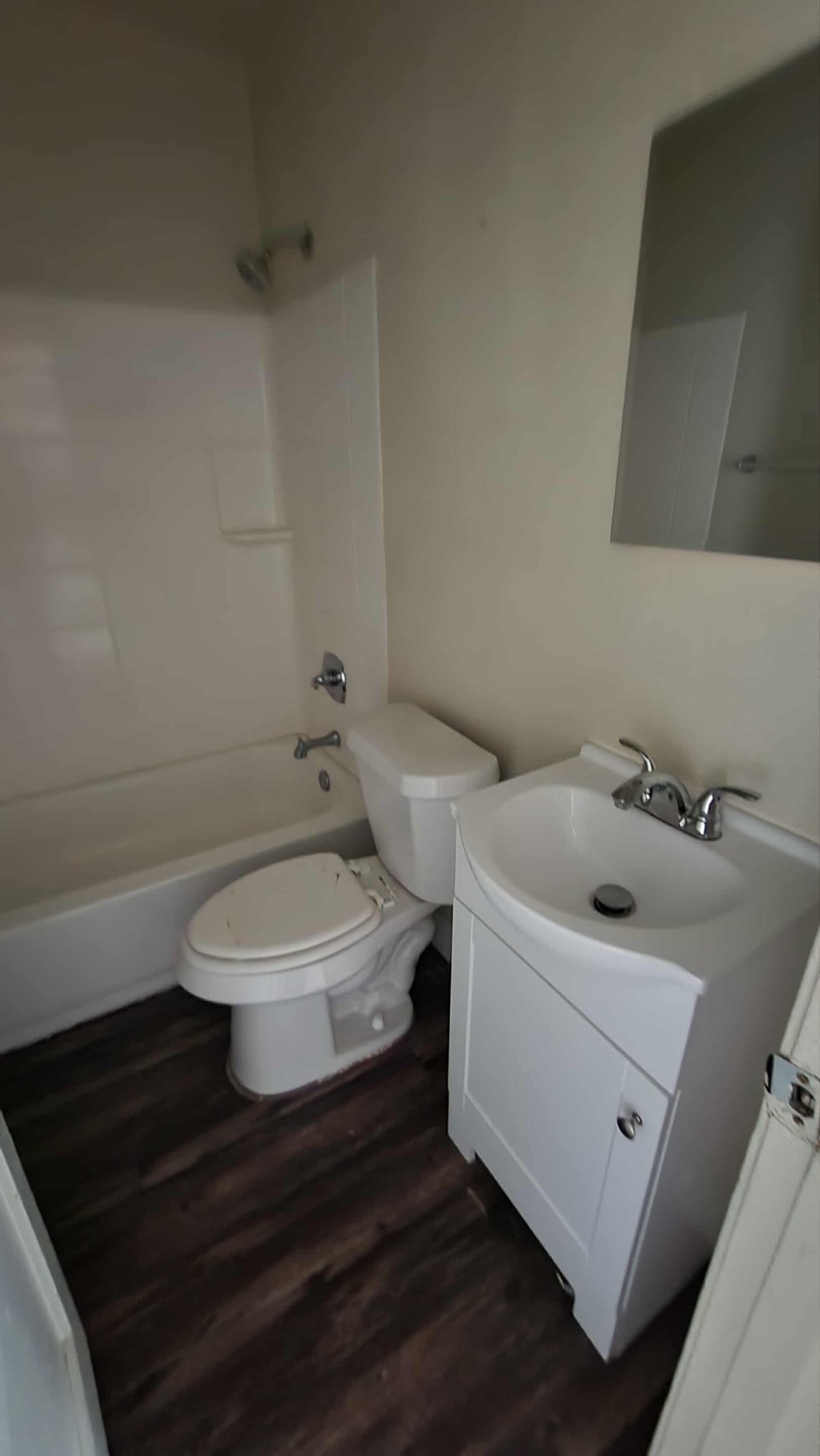 A white toilet and sink in a small bathroom.