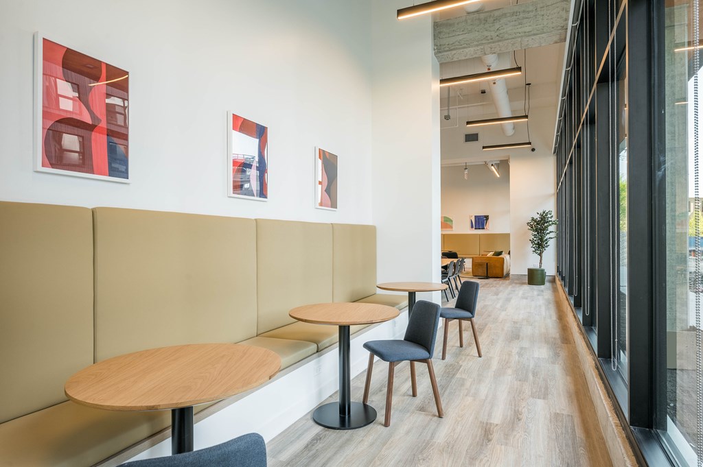 A long hallway with tables and chairs on the side.