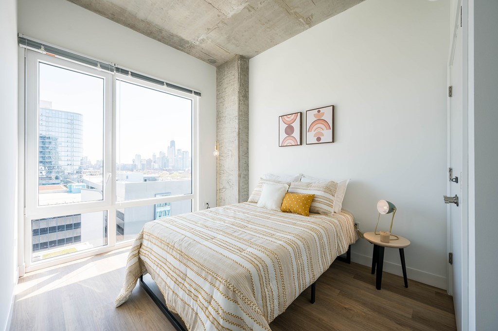 A bedroom with a large bed and a view of the city.