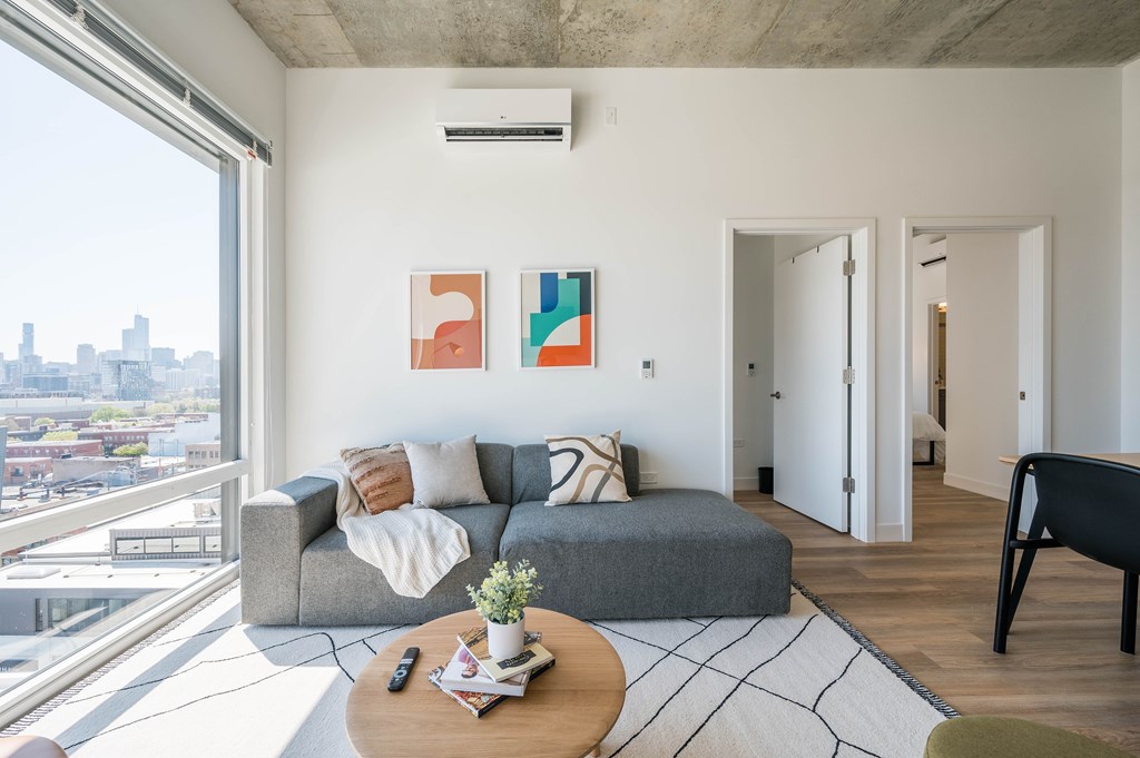 A living room with a grey couch and two abstract paintings on the wall.