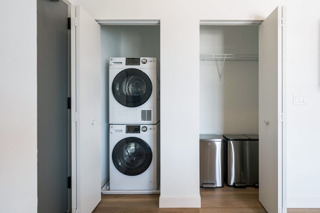 A white front loading washing machine in a laundry room.