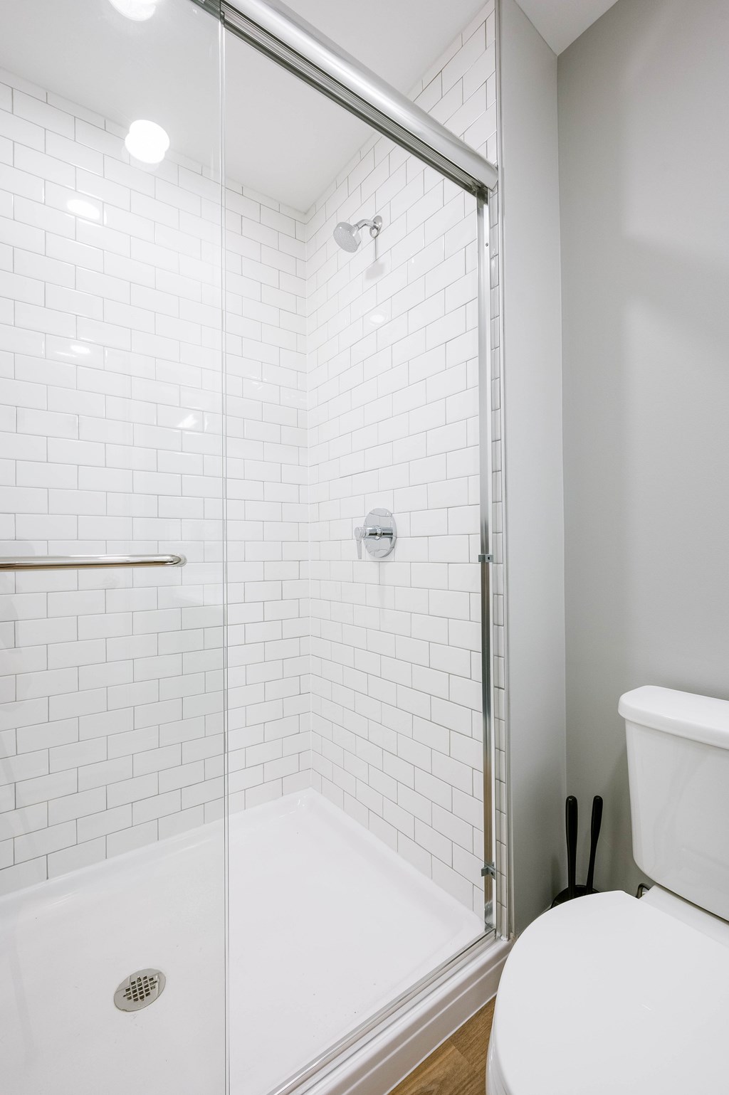 A white toilet sits next to a walk-in shower.