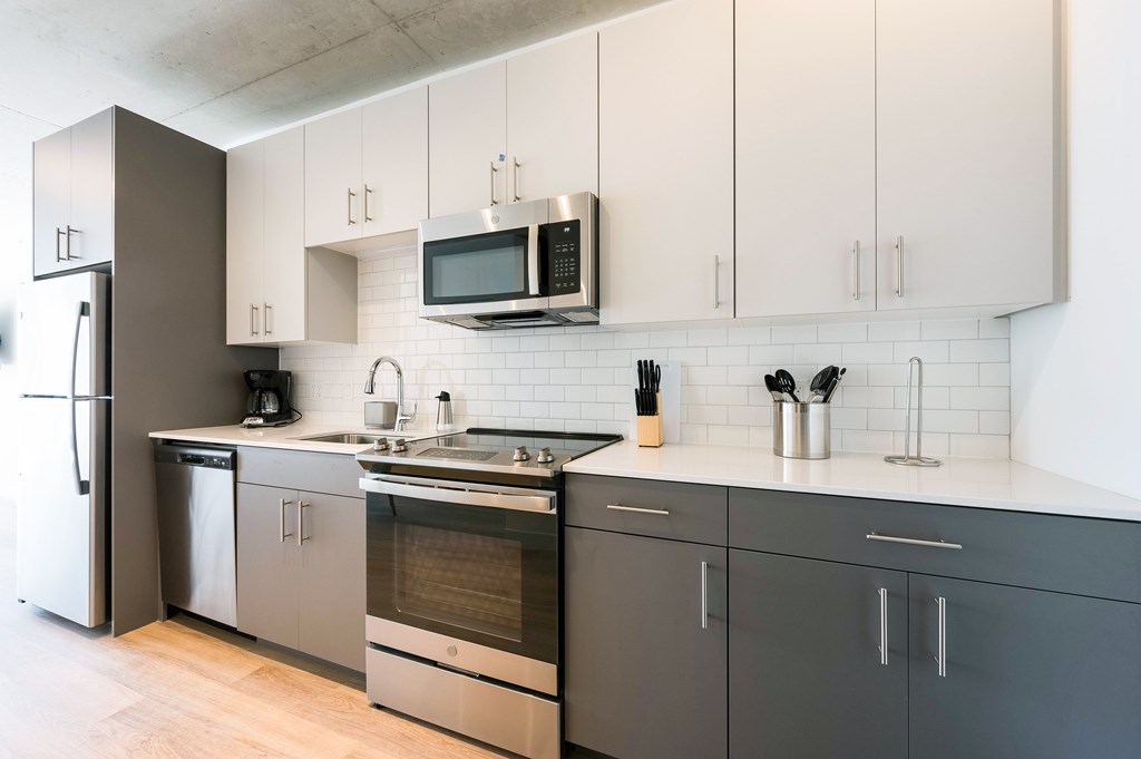 A modern kitchen with a stainless steel refrigerator and a black oven.