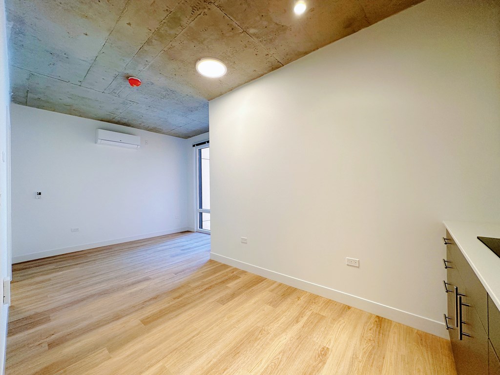 A room with wooden floors and a white wall.