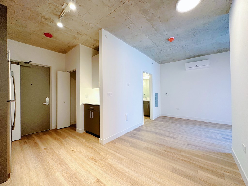 A room with a wooden floor and a concrete ceiling.