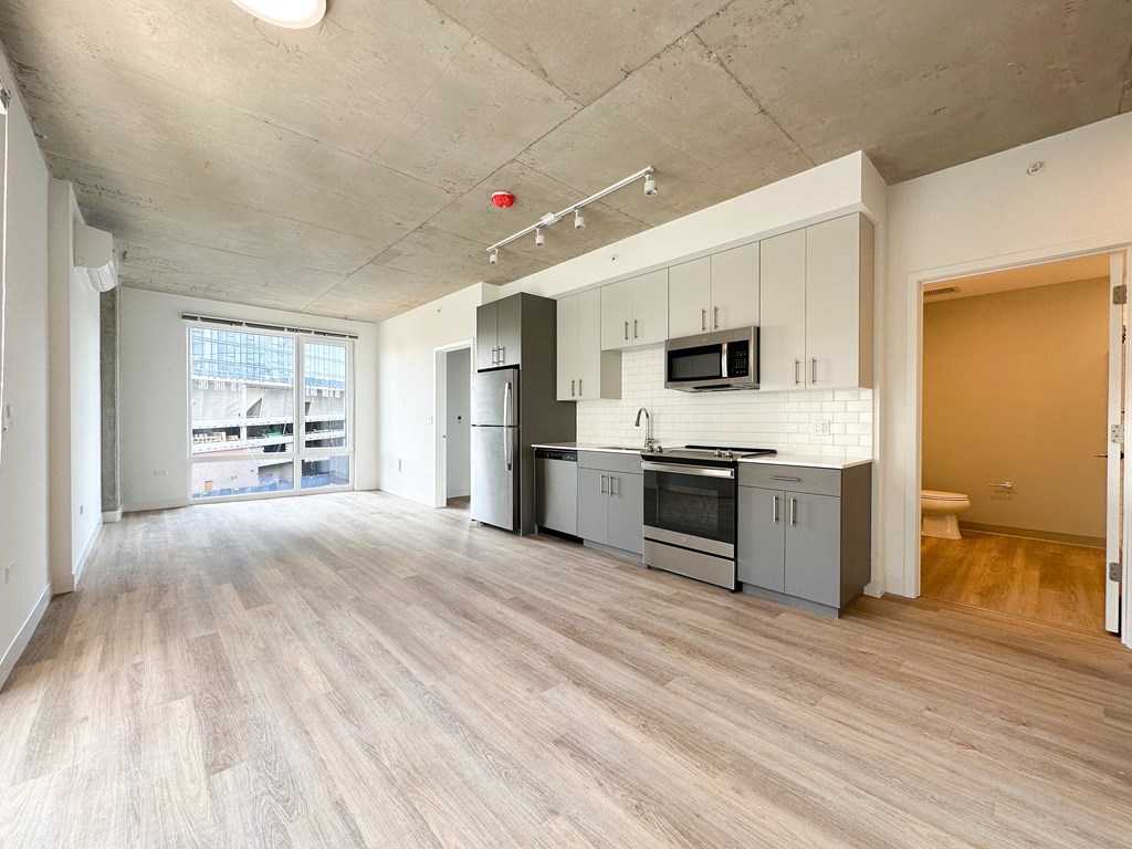 A kitchen with white cabinets and a microwave above the stove.
