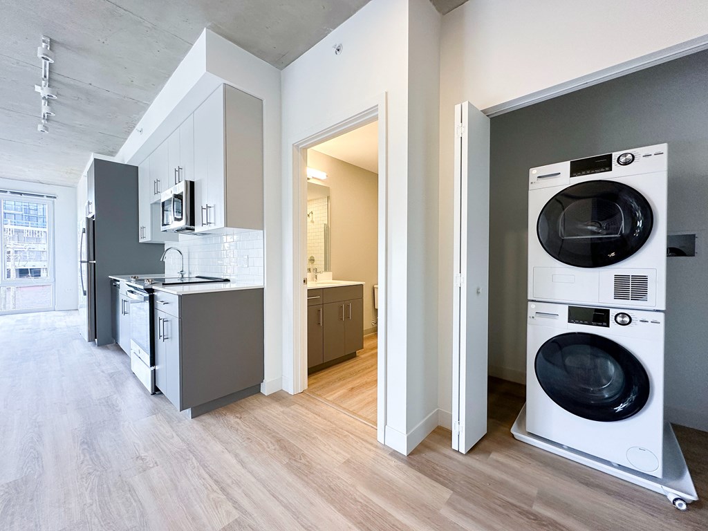 A modern kitchen with a washing machine in the doorway.