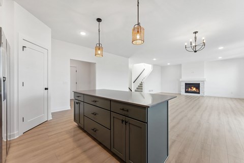 A kitchen with a white counter top and wooden floors.