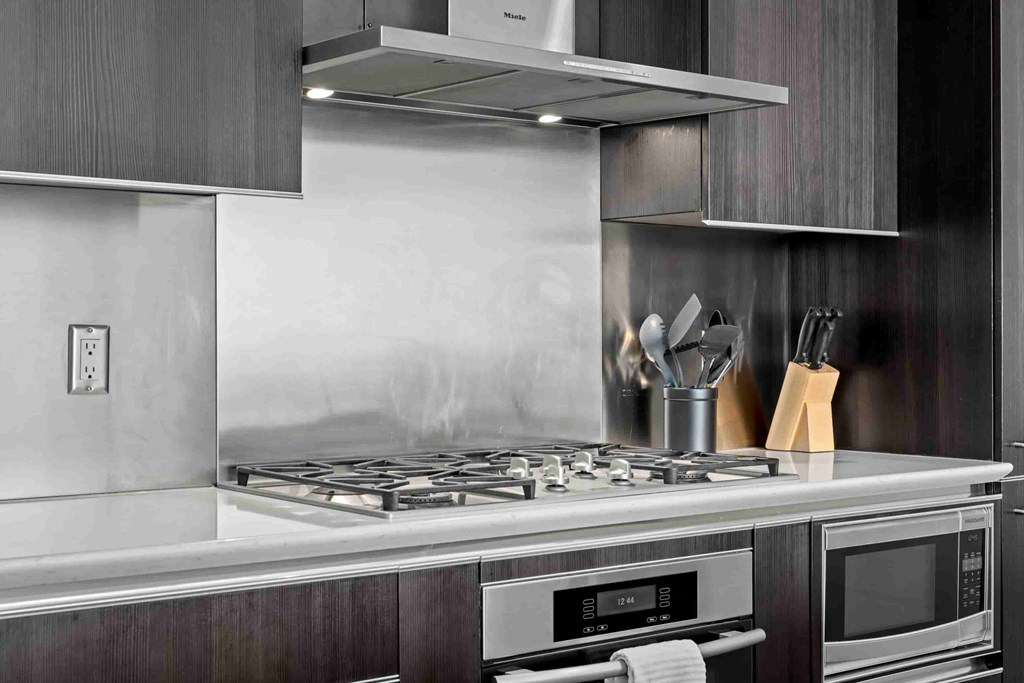 A modern kitchen with a stove top and oven.