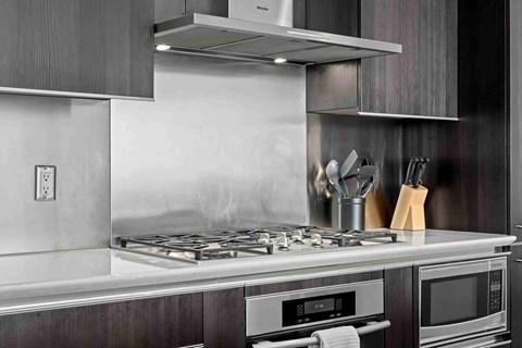 A modern kitchen with a stove top and oven.