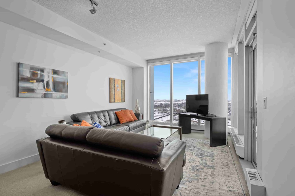 A living room with a brown couch and a flat screen TV.