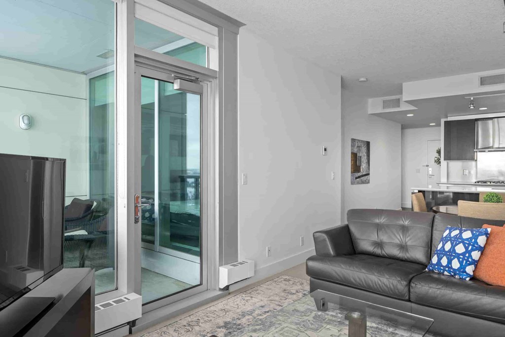A living room with a black couch and a television.