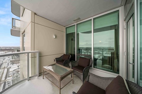 A balcony with a table and chairs overlooking a snowy landscape.