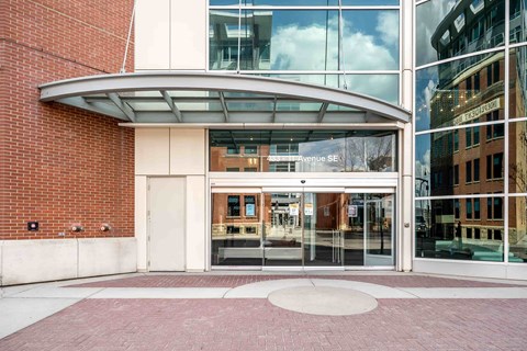 The entrance to a building with a glass door and a brick wall.