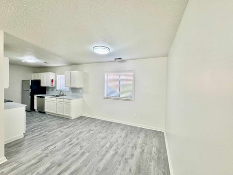 A kitchen with white cabinets and a refrigerator.