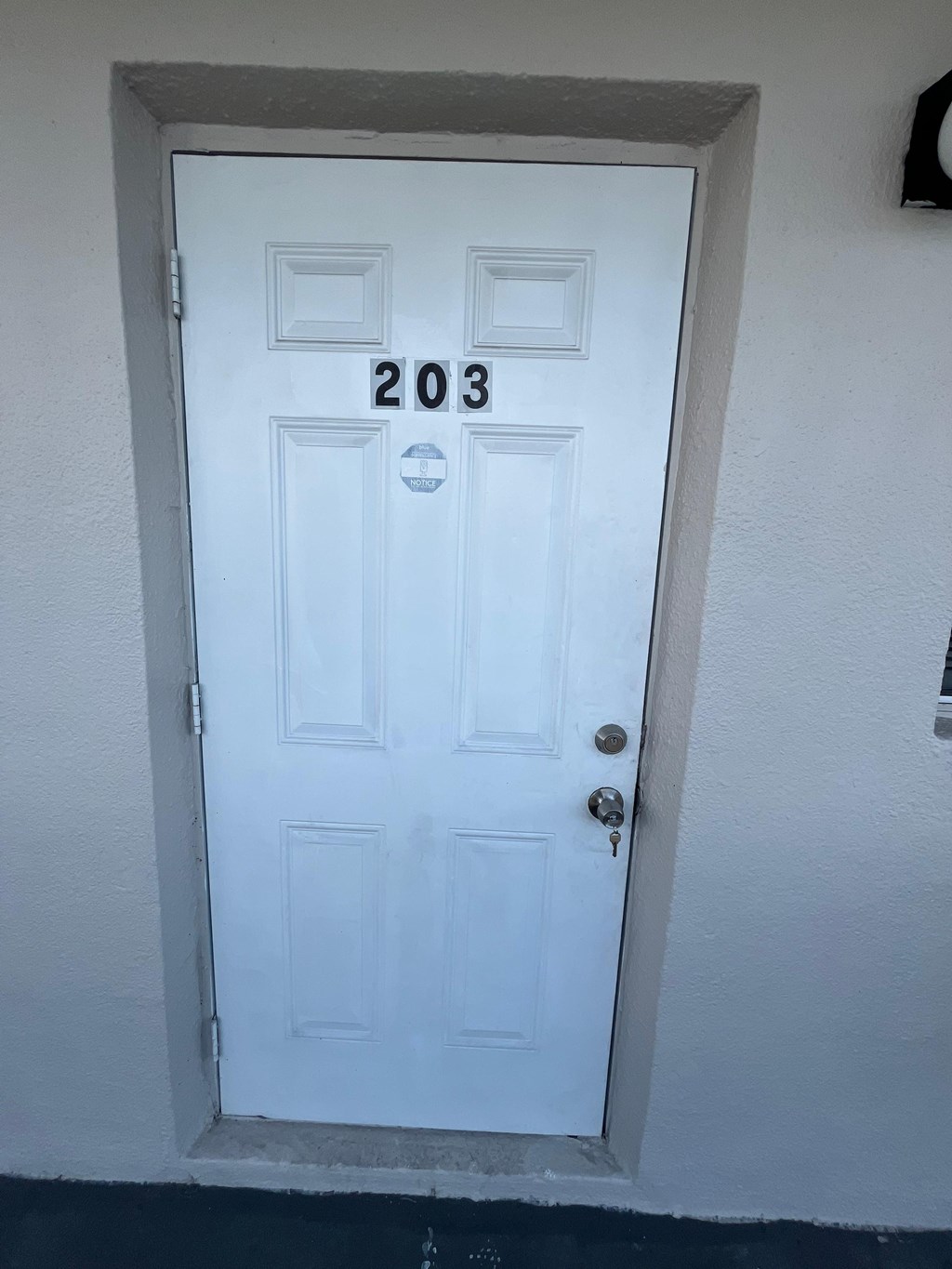 A white door with the number 203 on it.