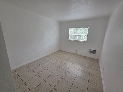 A room with a window and tiled floor.
