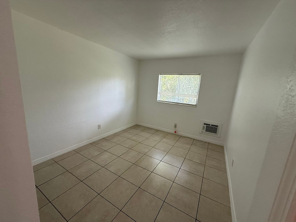 A room with a window and tiled floor.