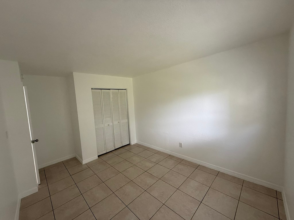 A room with a white ceiling, a white door, and a white cabinet.