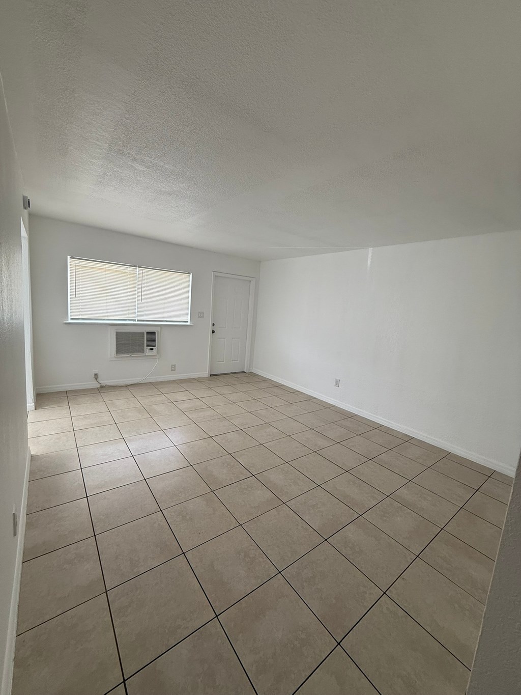 A room with tiled flooring and a window.