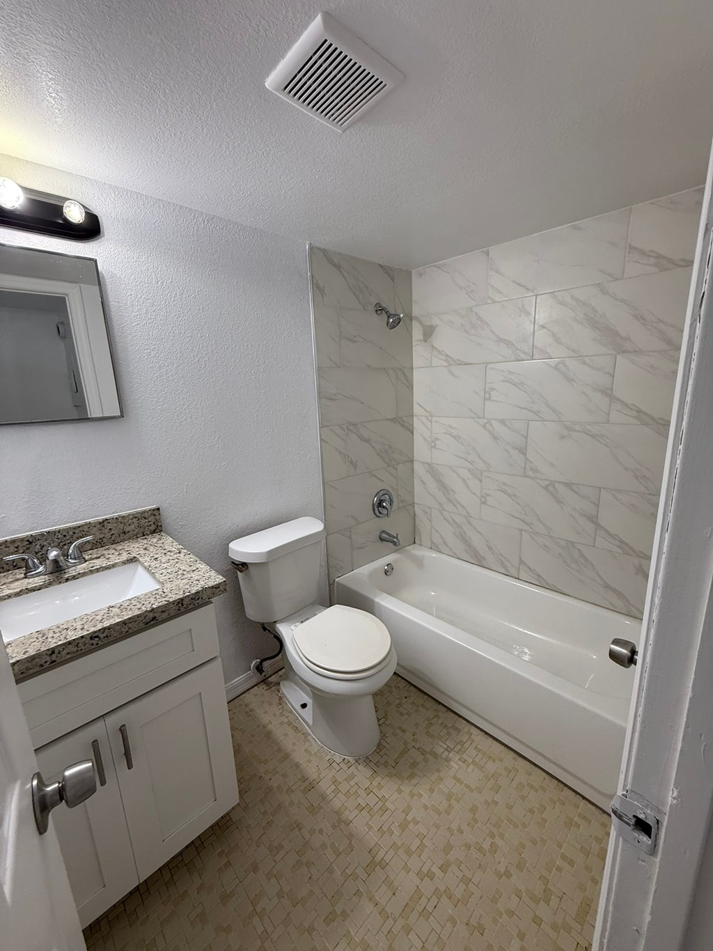 A white bathroom with a sink, toilet, and bathtub.