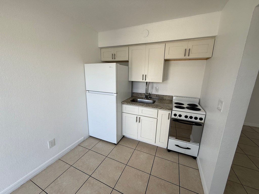 A kitchen with white appliances and cabinets.